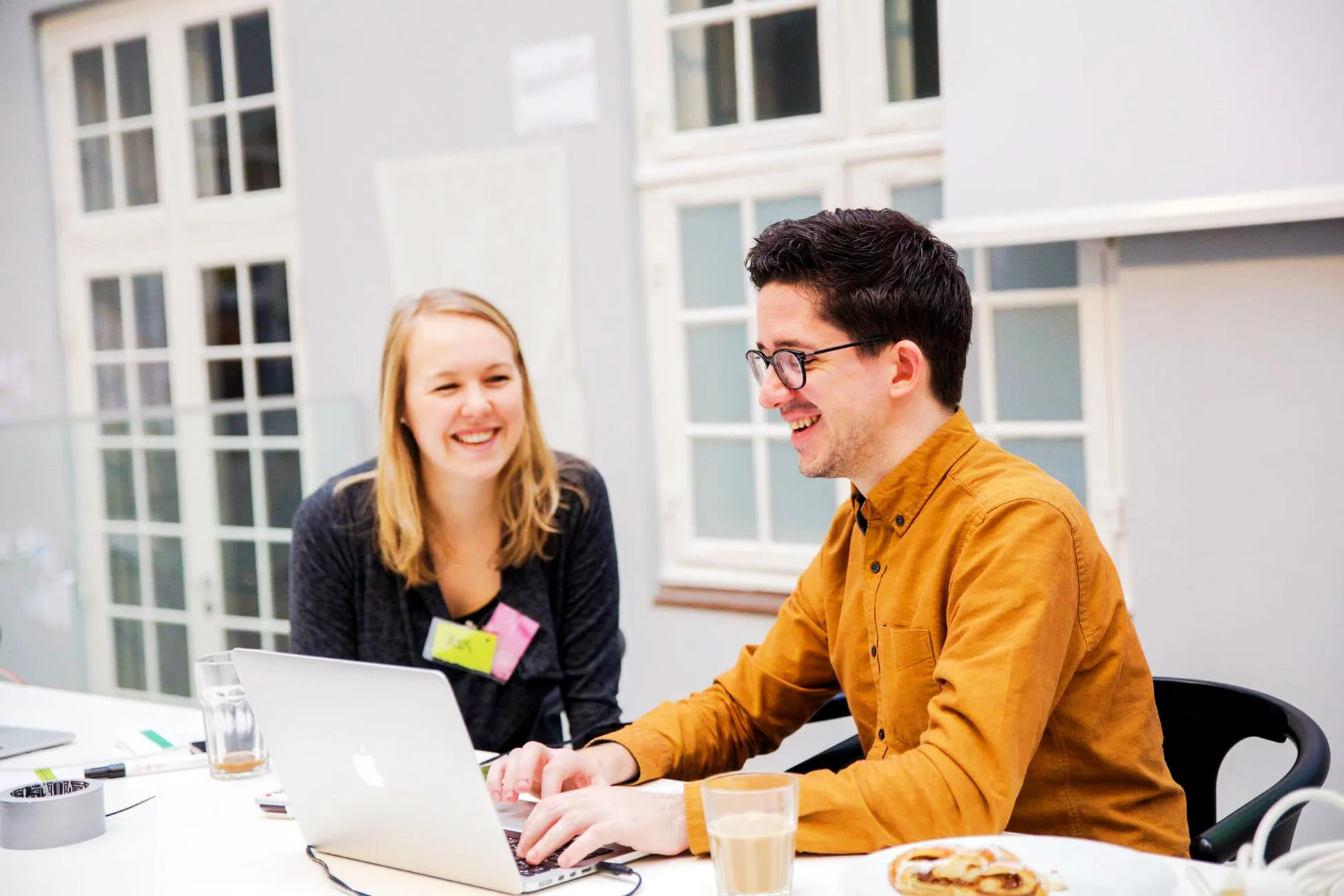 Image of Kevin smiling while in conversation with another designer.